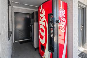 una máquina expendedora de cocacola junto a un edificio en Moonlight Inn - Houston I-45 & Airline, en Houston