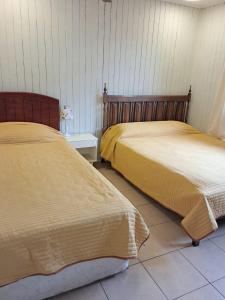 two beds sitting next to each other in a room at Acogedora casa en la playa in El Quisco