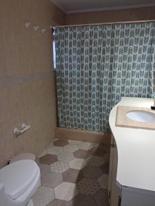 a bathroom with a toilet and a sink and a shower at Acogedora casa en la playa in El Quisco +14 photos