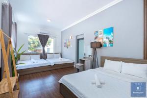 a bedroom with two beds and a window at Villa 51 LVC - Free Bida - Phòng Karaoke Máy Lạnh - Gần Biển Bãi Sau Thùy Vân in Vung Tau +19 photos
