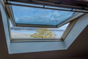 una ventana en el techo de una habitación con un árbol en Ti Gwer - vue mer - wifi, en Crozon 13 fotos más