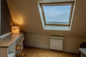 Habitación con ventana y escritorio con radiador. en Ti Gwer - vue mer - wifi, en Crozon