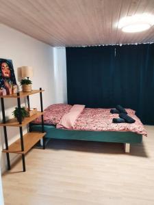 a bedroom with a bed with a blue wall at Cozy basement apartment in the center in Hirtshals