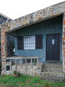 ein blaues Haus mit Holztür und Treppe in der Unterkunft Mountain Cottage Graciosa Azores in Almas