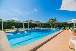 une piscine avec chaises et parasols sur un patio dans l'établissement Villa La Rosaleda - By Dream Villas Pollensa, à El Port