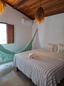a bedroom with a bed with a hammock in it at Casa Barrinha in Acaraú +8 photos