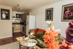 a living room with a couch and a table and a kitchen at Bromley jefersons place in Bromley
