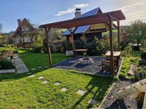 a backyard with a wooden pergola and a bench at Chatička Lukov in Lukov