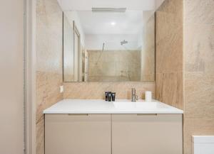 Un baño con un lavabo blanco y un espejo. en Classbnb-Spacious mountain Apartment just 500m from the ski lifts, en Breuil-Cervinia