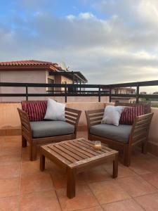 eine Terrasse mit 2 Stühlen und einem Couchtisch auf dem Balkon in der Unterkunft Casa de Origo Mare in Lajares