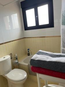 ein Bad mit einem WC, einer Badewanne und einem Fenster in der Unterkunft Casa de Origo Mare in Lajares + 23 Fotos