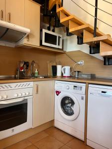 eine Küche mit Waschmaschine und Mikrowelle in der Unterkunft Casa de Origo Mare in Lajares