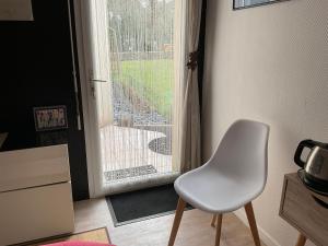 a white chair sitting in front of a door at Chambre d hôtes in Crach