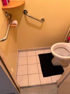 uma casa de banho com um WC e um tapete preto em Champions Deluxe em Sarcelles mais 63 fotografias