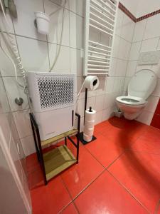 a bathroom with a toilet and a red floor at Apartmany u Synagogy in Třebíč +66 photos