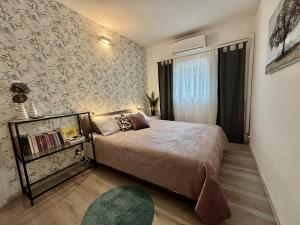 1 dormitorio con cama y pared con papel pintado en Umag Romantic Apartment, en Umag