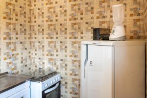 a kitchen with a white blender on top of a refrigerator at Apto Centro de Búzios - 2 Quartos - Ar-condicionado in Búzios