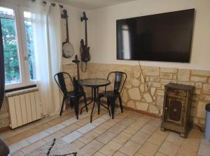 a living room with a table and chairs and a television at Studio avec chambre Camargue in Arles