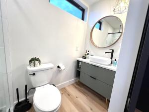 a bathroom with a toilet and a sink and a mirror at Wild Sage in Orderville +8 photos