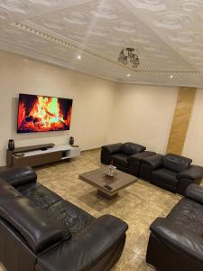 a living room with leather furniture and a flat screen tv at Seven suite in Brazzaville