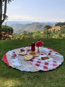a picnic table with plates of food and flowers on it at Chalé da Sorte in Gonçalves