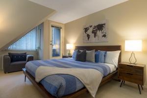 a bedroom with a large bed and a chair at Spacious Benchlands Chalet by Harmony Whistler in Whistler