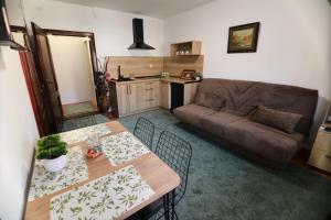 a living room with a table and a couch at Apartmani Varos & Restaurant in Pirot