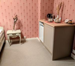 a small kitchen with pink wallpaper and a table at Rauhalahden Kartano in Kuopio