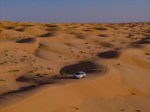 a white truck driving through the desert at Infinity Camp in Bidiyah