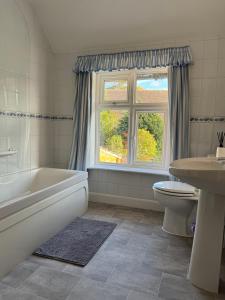 a bathroom with a tub and a toilet and a sink at Town House, Stratford-upon-Avon in Stratford-upon-Avon