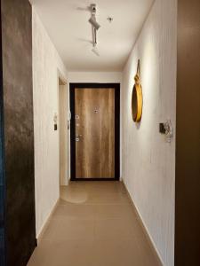 a hallway with a wooden door in a room at Royal Kate SPA included, 32nd floor in Skopje +26 photos