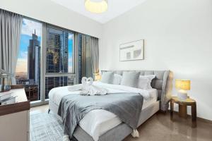 ein Schlafzimmer mit großem Bett und großem Fenster in der Unterkunft FIRST CLASS 1BR Charming City View in Dubai + 37 Fotos