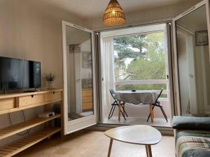 a living room with a large sliding glass door at La Mascotte de Sète studio cabine Pking in Sète