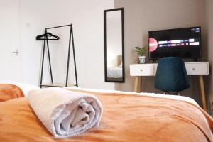 a bedroom with a bed and a tv and mirror at Top Spot 2-Bed Spacious Apartment Town Centre Train Station WIFI in Colchester