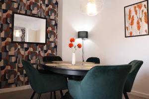 a dining room table with green chairs and a mirror at Top Spot 2-Bed Spacious Apartment Town Centre Train Station WIFI in Colchester