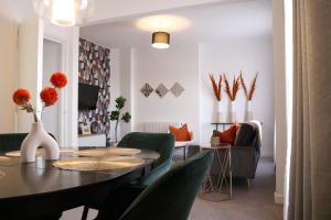 a living room with a table and green chairs at Top Spot 2-Bed Spacious Apartment Town Centre Train Station WIFI in Colchester