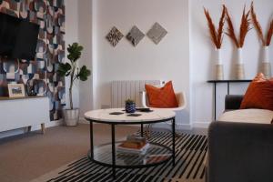 a living room with a table and a couch at Top Spot 2-Bed Spacious Apartment Town Centre Train Station WIFI in Colchester