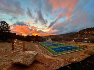 two tennis courts with a sunset in the background at Airstream Dream in Orderville