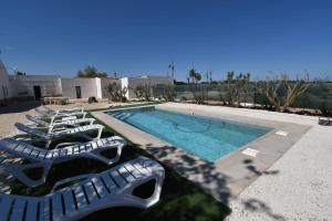 a group of lounge chairs next to a swimming pool at Sweetstaybykw Amplia Casa de Campo con Piscina in Asprillas