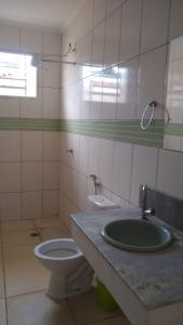 une salle de bain avec un lavabo et des toilettes dans l'établissement Cantinho do Sossego, à Olímpia
