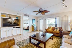 Una sala de estar con un sofá y un televisor. en Saida Towers II Unit 306, en South Padre Island