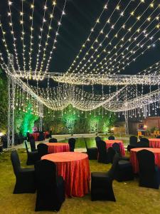 a room with tables and chairs and lights at Krishnam Resort in Jabalpur +29 photos