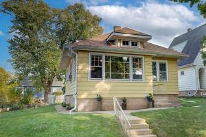 a yellow house with stairs in a yard at Stylish home Garage Walk to Lake Minutes from Airport in Saint Francis