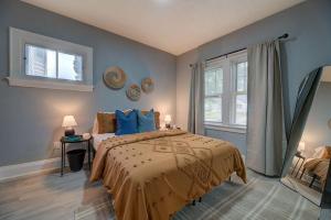 a bedroom with a bed with blue walls and a window at Stylish home Garage Walk to Lake Minutes from Airport in Saint Francis