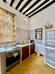 a kitchen with a sink and a stove top oven at Tumbo Swahili Villa in Gulioni