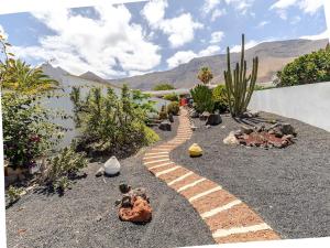 a garden with a brick path and a cactus at Casa Susanne in Famara