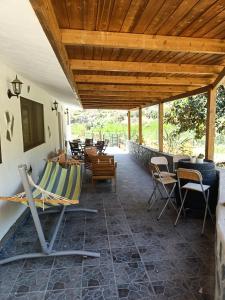 a patio with chairs and tables and a wooden ceiling at Casa Rural La Hoyita de Tunte in San Bartolomé