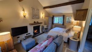 a living room with a couch and a fireplace at The Hideaway in Shepton Mallet