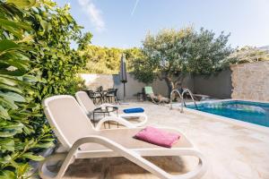a patio with a pool and chairs next to a swimming pool at Pietro in Korčula