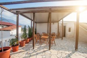 a patio with a wooden pergola and tables and chairs at Rooms and Apartments Milana in Bar
